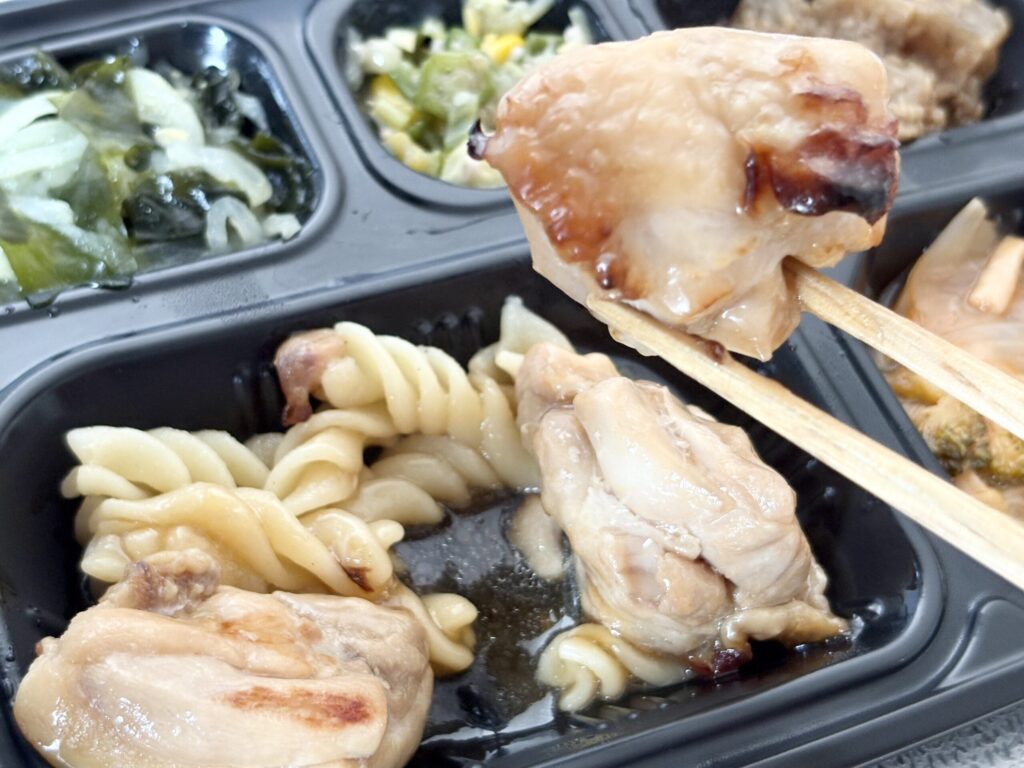 ワタミの宅食ダイレクトの照り焼きチキンを箸で持ち上げた実食写真