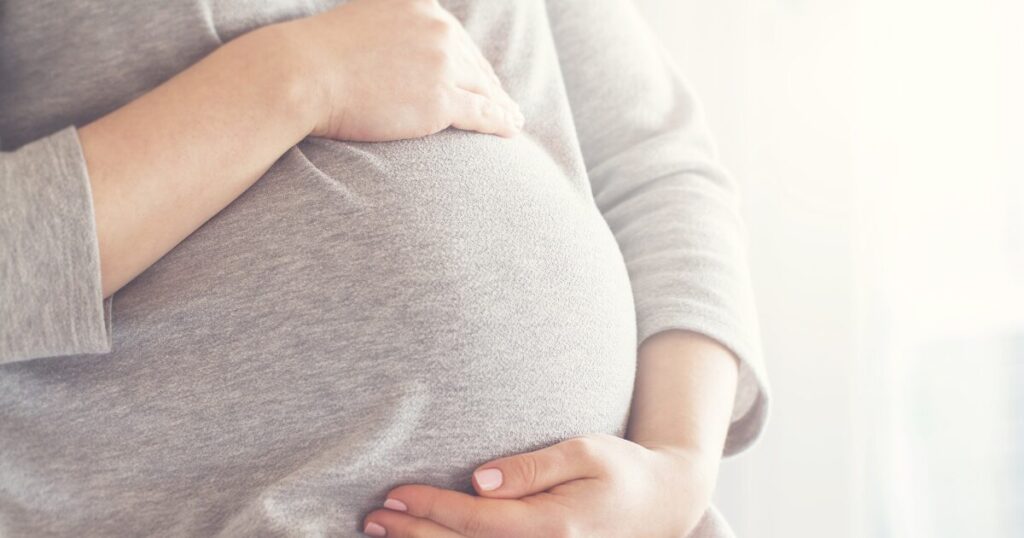 妊娠中のお腹に手を添えたイメージ写真